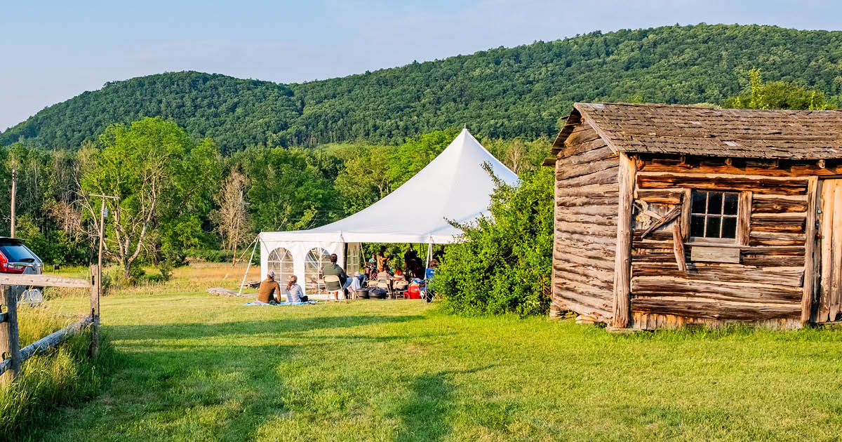 Labyrinth stage tent and French Azilum cabin at sunset