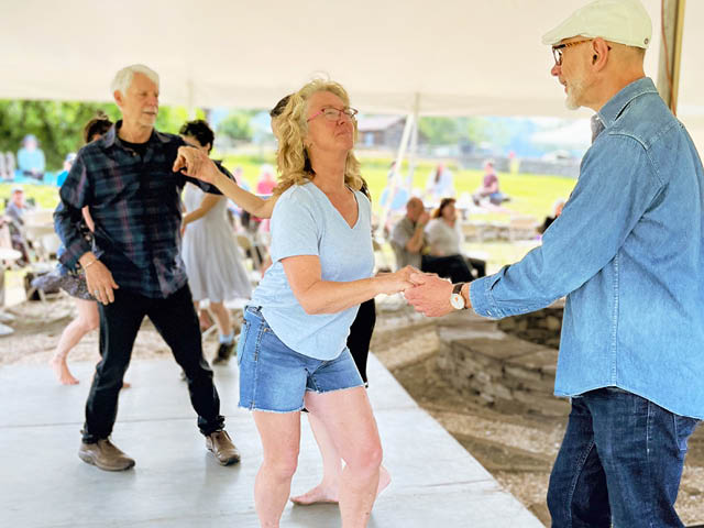 Festival attendees line dancing on the Labyrinth Stage at the 2023 Susquehanna Summer Solstice Fest